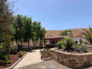 una casa con una pared de piedra junto a un jardín en Villa Margarita, en Valle de Santa Inés