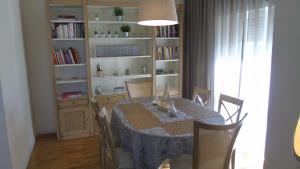 a dining room with a table and a book shelf at Oporto Beach in Gulpilhares