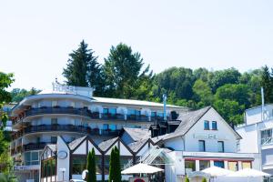 a hotel in front of a building with trees at Hotel Lorösch in Bad Orb