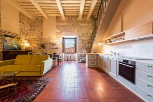a kitchen and living room with a couch and a table at Nella Torre del Poschi Penthouse with Roof Terrace in Pisa