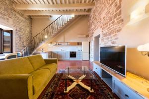 a living room with a couch and a tv at Nella Torre del Poschi Penthouse with Roof Terrace in Pisa