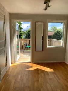 an empty living room with a door and a mirror at 2 rum och kök på Färjestad in Karlstad