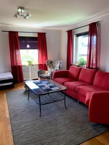 ein Wohnzimmer mit einem roten Sofa und einem Tisch in der Unterkunft 2 rum och kök på Färjestad in Karlstad