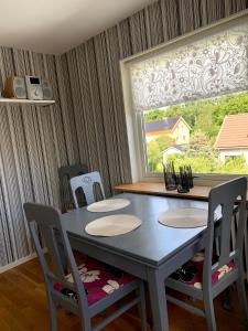 a dining room table with chairs and a window at 2 rum och kök på Färjestad in Karlstad