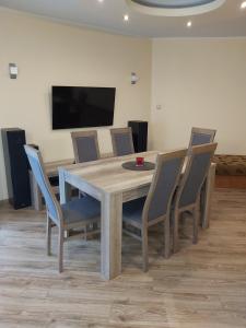 uma mesa de jantar com cadeiras e uma televisão em Apartament Beata em Jastrzebia Gora