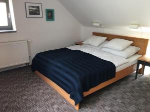 Apartmán pod Velkou Amerikou في Mořina: غرفة نوم بسرير كبير مع وسادتين