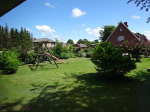a playground in a yard next to a house at Ferienwohnung Schwiemann, Obergeschoss in Cadenberge