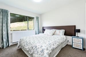 a bedroom with a bed and a large window at Hunters Moon in Mosgiel