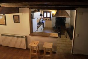 a kitchen with two stools and a kitchen with a stove at Piedra Andadera II in Soria