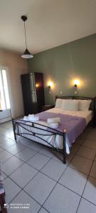 a bedroom with a large bed with purple sheets and pillows at Aiolos II in Skala Potamias