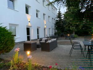 une terrasse avec un canapé et des chaises en face d'un bâtiment dans l'établissement Bell's Hotel, à Konstantynów Łódzki