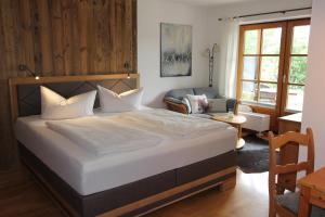 a bedroom with a large bed and a living room at Haus Bergblick in Rieden am Forggensee
