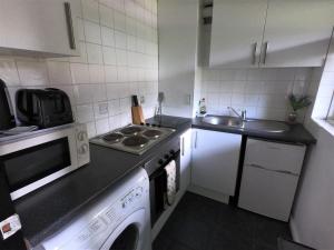 una pequeña cocina con fregadero y microondas en Town Centre Studio Flat! en Basingstoke