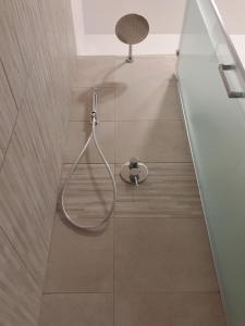 un bagno con doccia, sedia e pavimento di The Shell Guest House ad Alghero Altre 18 foto