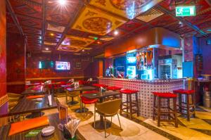 eine Bar mit Tischen und Hockern in einem Raum in der Unterkunft Royalton Hotel in Dubai