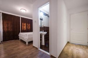 baño con lavabo, cama y espejo en Casa 4 Odăi, en 23 August