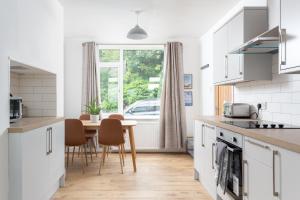 cocina con mesa, sillas y ventana en LOOK at the Views - Huddersfield Haven Sleeps 6, en Huddersfield