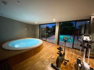 a gym with a large jacuzzi tub and exercise equipment at Logis Hostellerie des Ducs in Duras