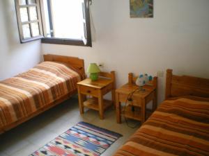 a bedroom with two beds and a window and a rug at Bayview Apartments in Agios Nikolaos