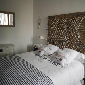 una camera da letto con letto, lenzuola e cuscini bianchi di Une affaire de famille a Le Portel