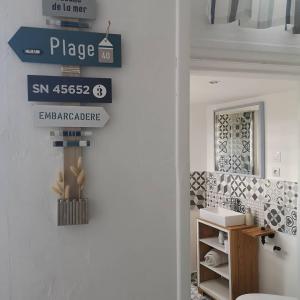 uma casa de banho com uma placa na parede ao lado de uma porta em Une affaire de famille em Le Portel