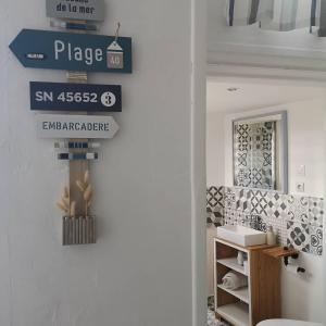 a bathroom with a sign on the wall next to a door at Une affaire de famille in Le Portel +12 photos