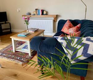 ein Wohnzimmer mit einem blauen Sofa und einem Tisch in der Unterkunft Atlantic Garden Lodge in Lisdoonvarna