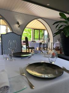 una mesa con un plato y vasos. en Logis Hostellerie des Ducs, en Duras