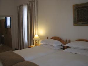 a hotel room with two beds and a window at Toverberg Guest Houses in Colesberg