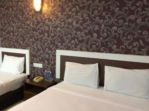 um quarto com 2 camas e uma parede com um padrão em CK Hotel em Malaca