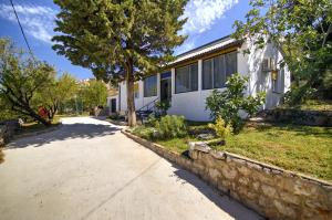 a house with a stone wall next to a driveway at Vacation home Korina in Senj