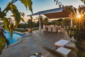 a patio with a table and chairs and a pool at Luxury Apartments White Villa Violeta in Mandre