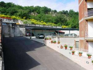 a parking lot with a car parked under a bridge at Hotel Reali in Chianciano Terme