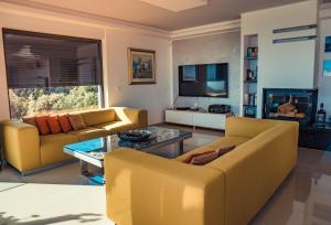 salon z 2 żółtymi kanapami i kominkiem w obiekcie Luxury Apartments White Villa Violeta w mieście Mandre