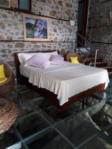 uma cama com almofadas cor-de-rosa num quarto em Nuci's Home glass floor em Tushemisht