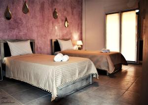 two beds sitting next to each other in a room at Magdalena Seaside Apartments in Nea Roda