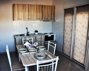 a kitchen with a wooden table with chairs and a tableasteryasteryasteryasteryastery at Magdalena Seaside Apartments in Nea Roda