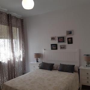 アルムニェーカルにあるPortobelloの白いベッドルーム(ベッド1台、窓付)