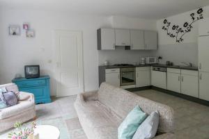 Il comprend un salon avec un canapé et une cuisine. dans l'établissement Knus tuin-appartement vlakbij Nijmegen voor 2 personen, à Molenhoek