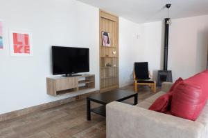 salon z kanapą i telewizorem z płaskim ekranem w obiekcie Apartamento con Piscina ADULTS ONLY w mieście Chiclana de la Frontera