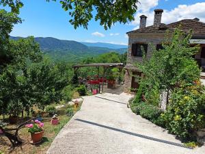 an old house with a pathway leading to a garden at Foris House in Vikos