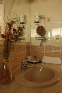 a bathroom sink with a vase with flowers in it at Salto Grande Hotel in Punta del Este