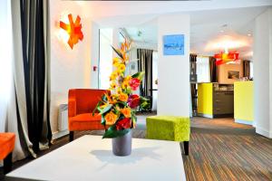 a living room with a vase of flowers on a table at Le Saint-Pierre in Mézidon-Canon