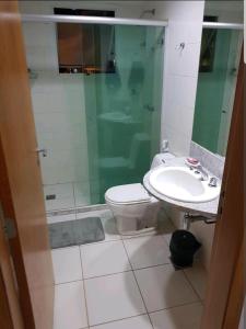 a bathroom with a toilet and a shower and a sink at FLAT BIARRITZ SETOR HOTELEIRO NORTE QUARTO 106 in Brasília