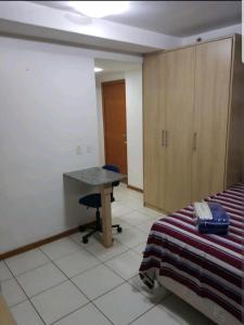 a room with a desk and a bed and a desk at FLAT BIARRITZ SETOR HOTELEIRO NORTE QUARTO 106 in Brasília