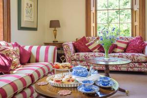 uma sala de estar com sofás e uma mesa com comida em Sissinghurst Castle Farmhouse em Sissinghurst