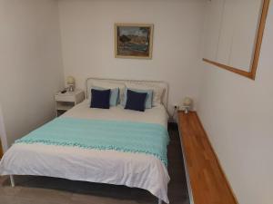 a bedroom with a white bed with blue pillows at Pension Oaza in Hvar