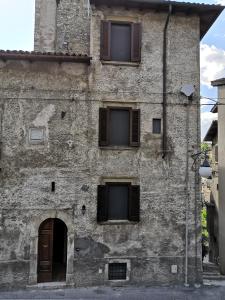 an old stone building with windows and a door at Alla Piazza Vecchia in Scanno