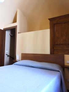 a bedroom with a bed with a wooden head board at Alla Piazza Vecchia in Scanno