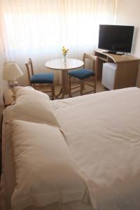 a bedroom with a bed and a table with a tv at Salto Grande Hotel in Punta del Este